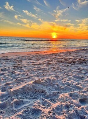 Ein Strand bei Sonnenuntergang über dem Meer.