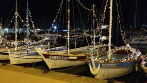 Several boats docked at a marina at night, illuminated by string lights. - Apartment in a quiet, private estate with swimming pool, tennis court and petanque area (Bormes-les-Mimosas)