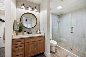 Een bad/douchecombinatie, een haardroger, handdoeken, zeep