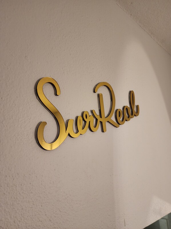 A gold wall-mounted sign with the text "SwirlReal".