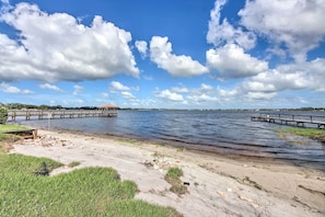 A riverside view with a wooden pier and a small building in the distance. - Pool & Fenced Yard: Sebring Retreat (Sebring)