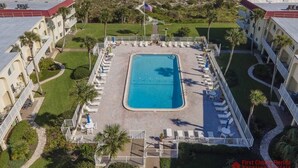 A hotel with a central swimming pool surrounded by lounge chairs and a view of the beach. - NEW LISTING ~ Spectacular Ocean Views ~ Professionally Decorated (Saint Augustine)