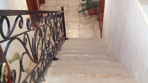 Una escalera con barandilla metálica que lleva a un rellano.
