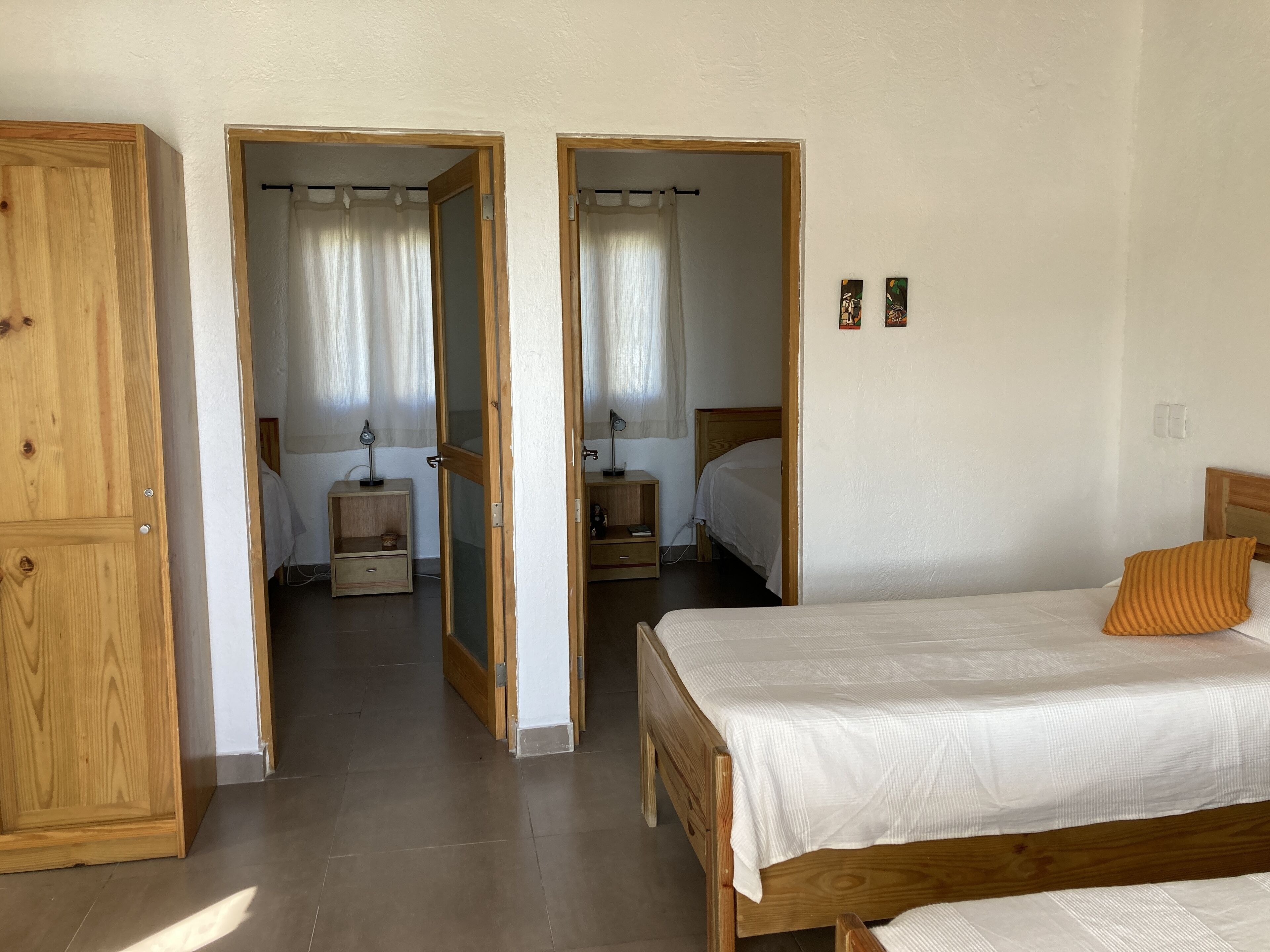Une chambre à coucher avec un lit en bois, une table de chevet, un miroir et une armoire.
