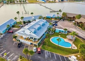 A hotel with a pool, parking lot, and a waterfront view. - Key Allegro charmer! Surrounded by Water! (Rockport)