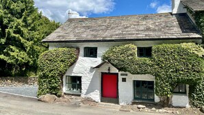 A traditional stone house with a red door, white walls, and green ivy. - Beautiful, 17th century Lake District cottage close to village and mountains (Coniston)