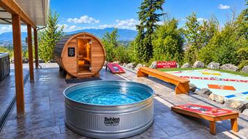 A pool area with a hot tub, a Monopoly game, and a view of mountains.
