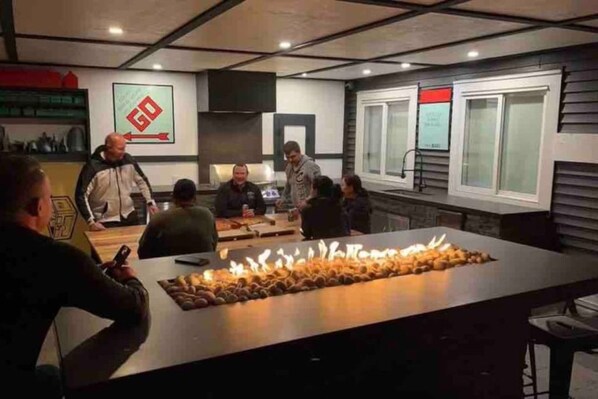 A group of people seated around a table with a large centerpiece of food.