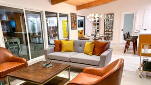 A modern living room with a grey sofa, brown leather chairs, and a wooden coffee table.