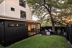 A modern house with a black exterior, a visible garage, and a well-maintained lawn.