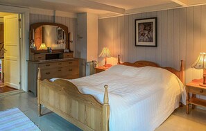 Cozy retreat with a four-poster bed, dresser, and bedside tables.