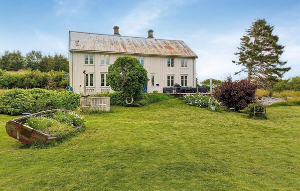 Stunning two-story building with a spacious lawn and a charming wooden dock.