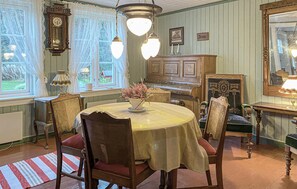 Classic dining room with a round table, comfortable chairs, and a wooden cabinet.