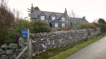 Mur de pedra amb un cartell de The Smithy House & Cottages.