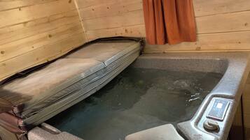 Eine Holzhütte mit Whirlpool, Holzwänden und Bedienfeld.
