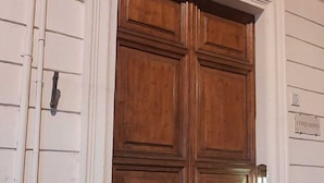 A large wooden double door with a sign above it reading "CONDOMINIO". - Quintus Luxury Suites (Rome)