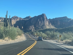 A road with vehicles, cacti, and mountains in the background. - Cabin 3 – Eagle's Nest - Queen Bed, Futon, Fireplace, Kitchen, Porch Swing (Gila County)