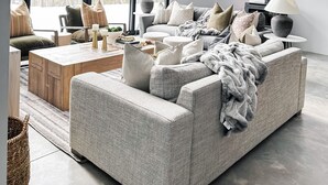 Una sala de estar moderna con un sofá grande de color gris, una mesa de centro de madera y una lámpara colgante.