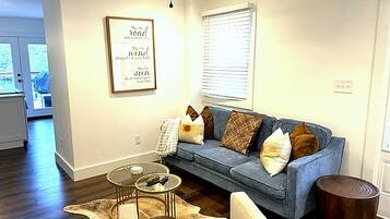 A living room with a sofa, a coffee table, and a rug.