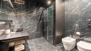 A modern bathroom with a marble floor, a sink, a bidet, and a toilet. - The King Of Milan (Milan)