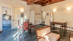 A spacious dining area with wooden furniture and a high ceiling with exposed beams. - Appartamento della Zecca - Affitti Brevi Italia (Lucca)