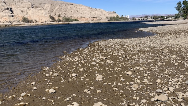 A riverbank with pebbles and a clear blue sky. - River house with scenic view (Bullhead City)