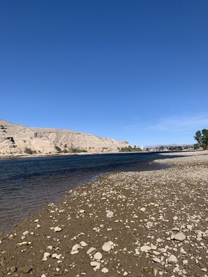 A riverbank with pebbles and a clear blue sky. - River house with scenic view (Bullhead City)