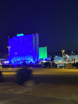 A large hotel with a prominent blue-lit facade and a smaller adjacent building. - River house with scenic view (Bullhead City)