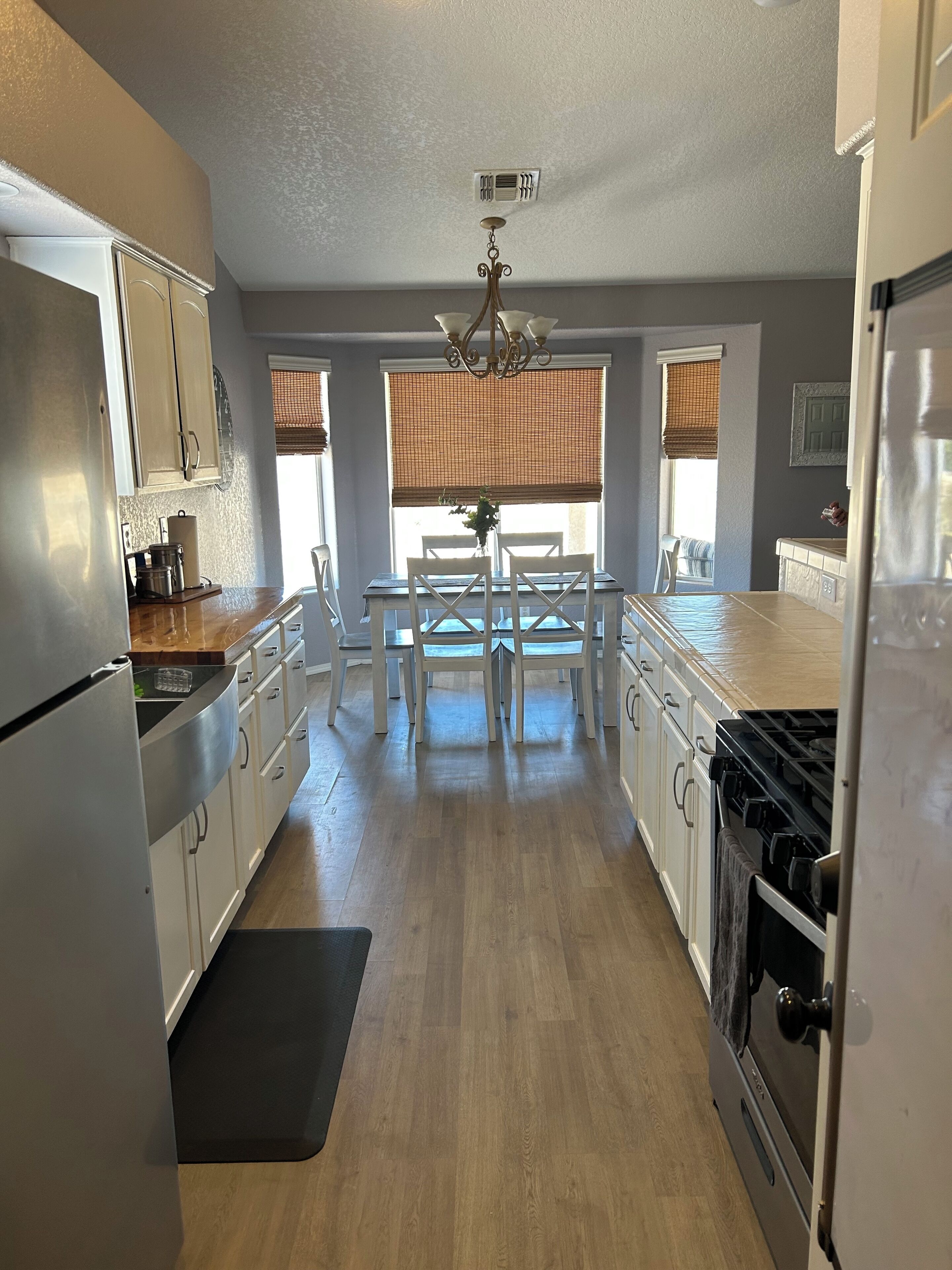 A modern kitchen with a central island, white cabinetry, and a stove.