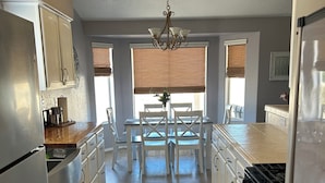 A modern kitchen with a central island, white cabinetry, and a stove. - River house with scenic view (Bullhead City)