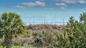 Eine Küstenlandschaft mit freiem Blick auf das Meer, umgeben von Vegetation und blauem Himmel.