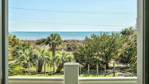 Blick auf einen Strand mit Palmen und blauem Himmel.