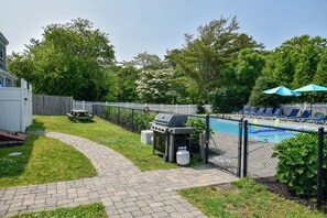 A backyard with a swimming pool, a barbecue grill, and lounge chairs. - Heated Pool AC 1/2 Mile to Beach! (Harwich)