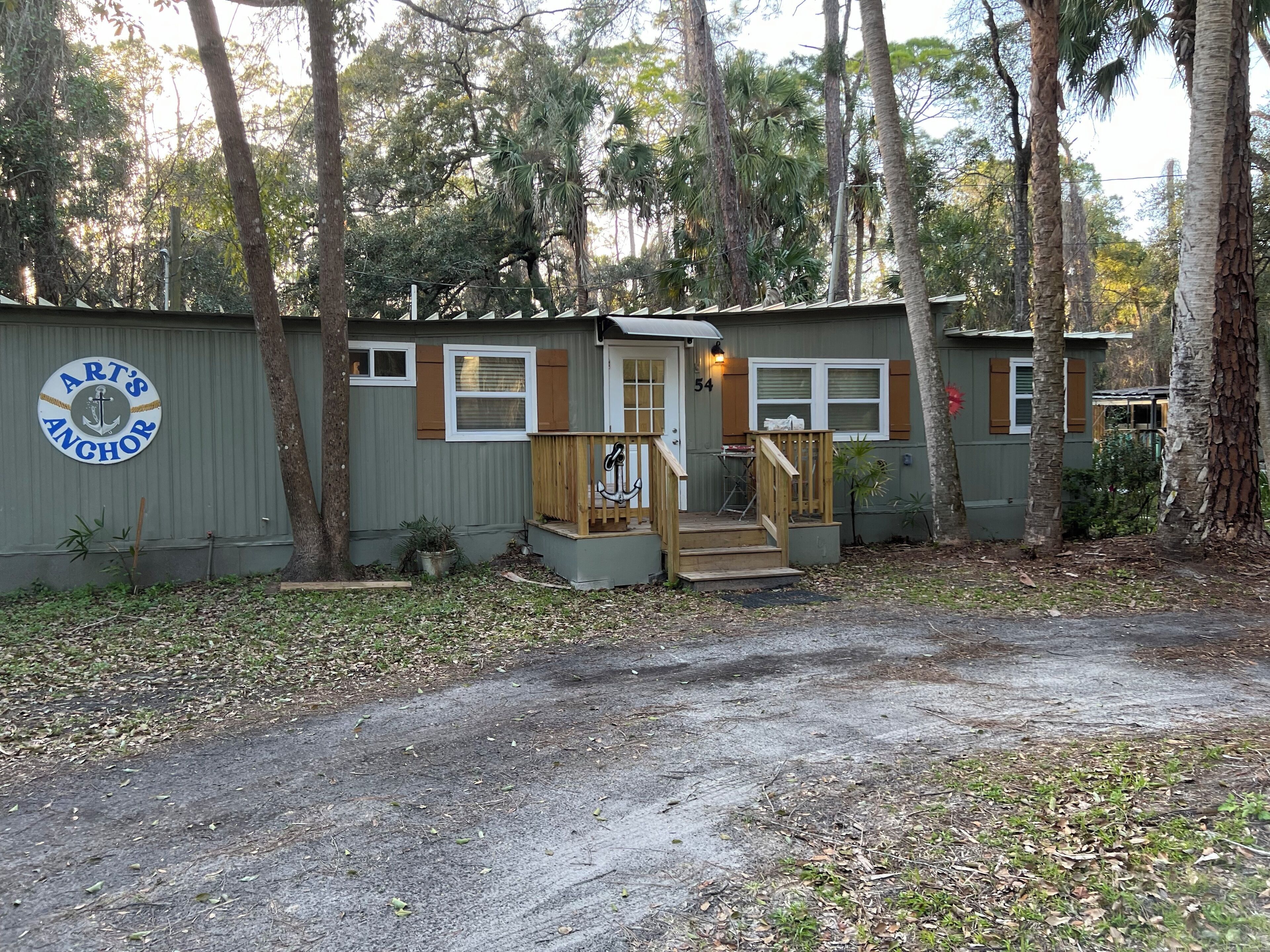 A small, single-story cabin with a porch and a mailbox.