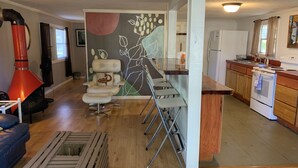 A modern kitchen with a bar area, wooden cabinets, and a red stove. - Nature Coast Inn and Cottages (Inglis)