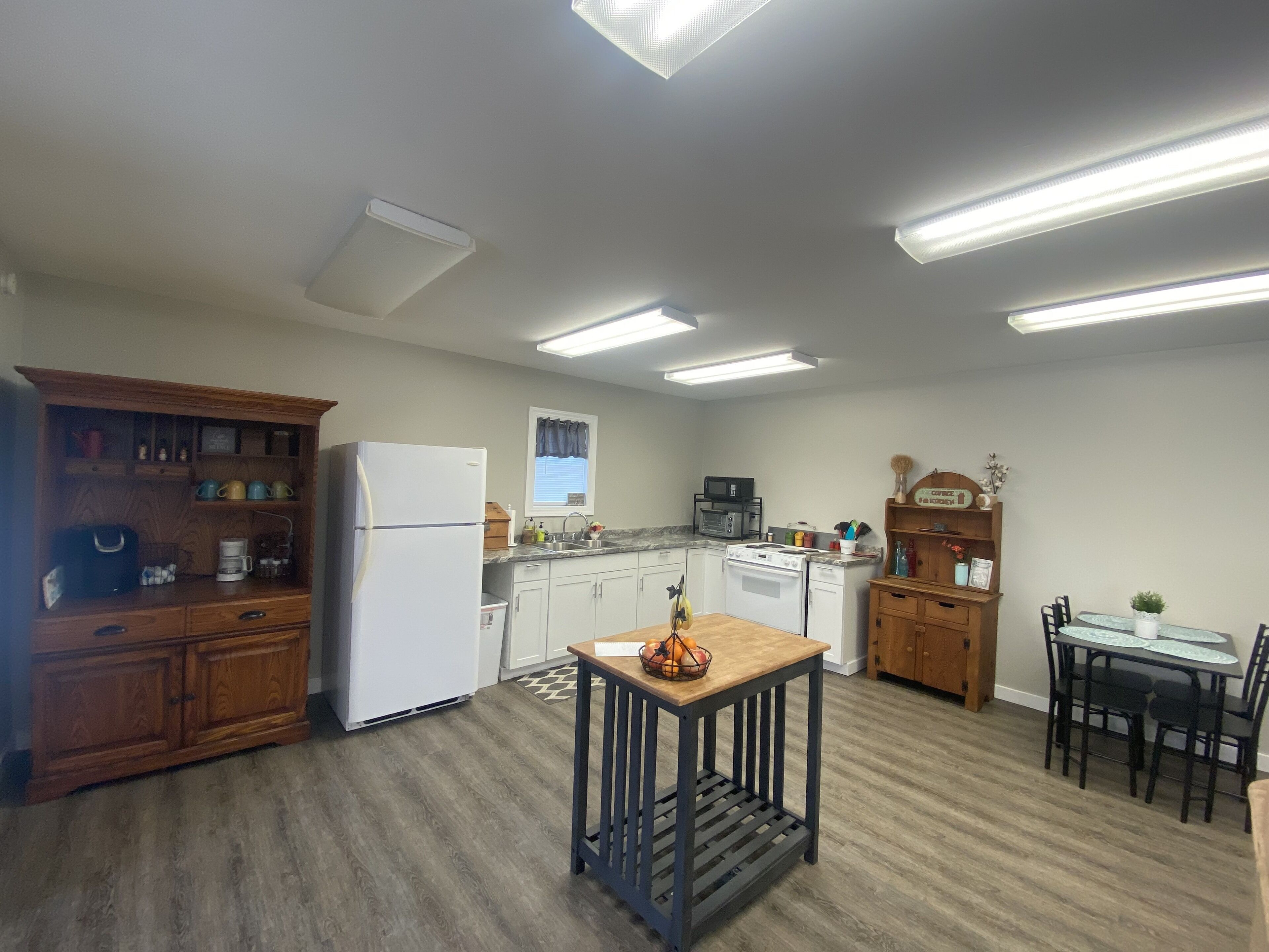 A kitchen with a refrigerator, stove, microwave, and wooden cabinets.