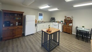 A kitchen with a refrigerator, stove, microwave, and wooden cabinets. - Cozy Cottage, Quiet and Peaceful, Minutes from Lake Guntersville (Grant)