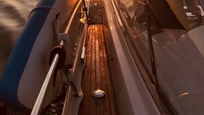 A boat deck with a view of the sunset over water. - Yacht "BAVARIA 37 SPORT "RIBELLE"" in Sardinia - with a sporty design (Olbia)
