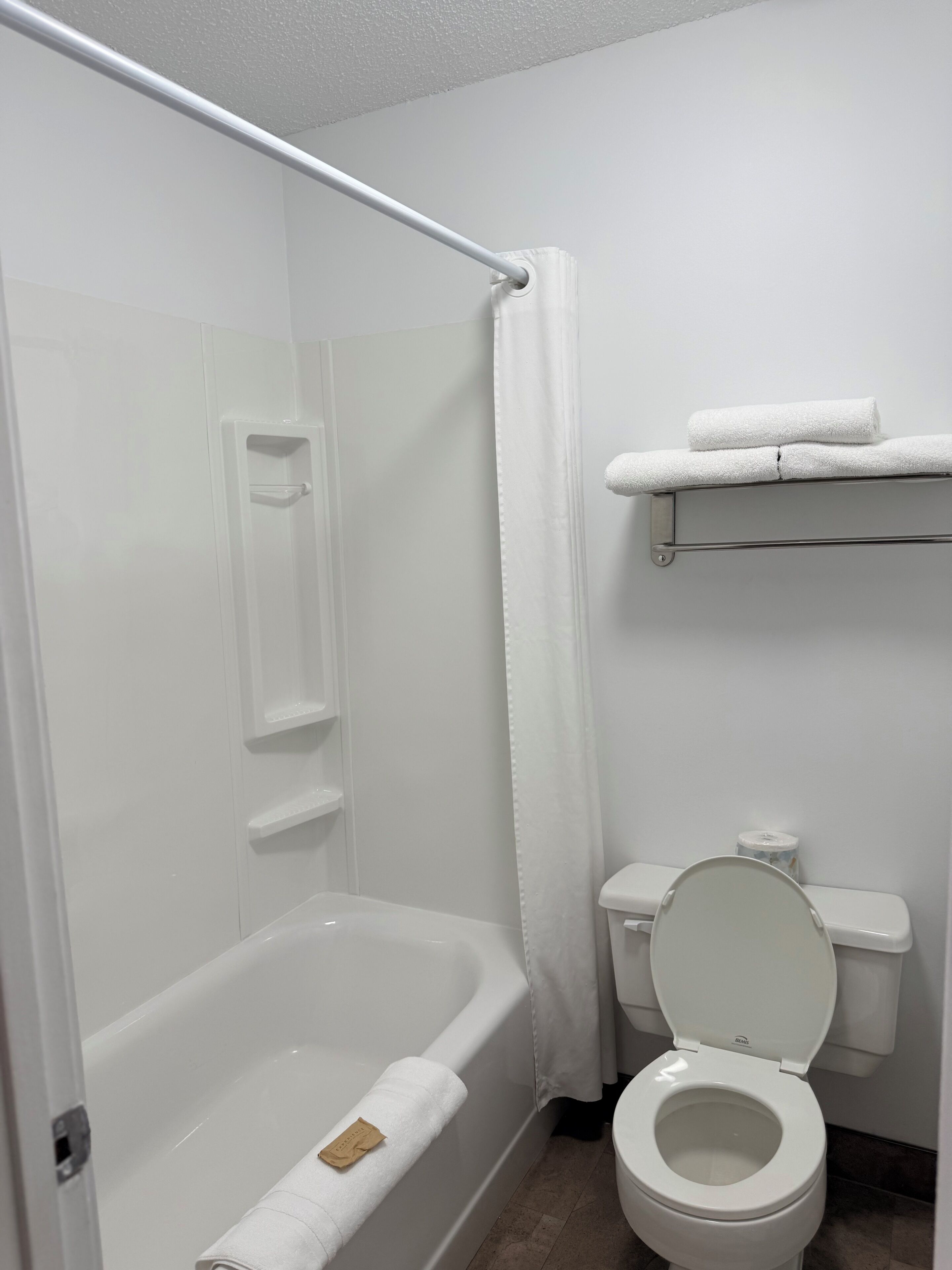 Un baño con bañera, inodoro y cortina de ducha.