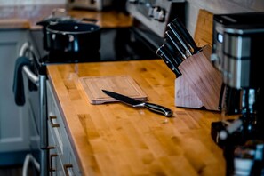 A kitchen counter with a cutting board, a knife, and a knife block. - 🌲 Serene Branson Hilltop Home: 4BR, 3BA Haven Near Branson's Best! 🌲 (Branson)