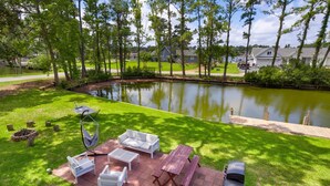 A patio with outdoor furniture, a grill, and a pond. - Sound Sanctuary: Canal Front w/ Dock, Dog-Friendly (Southern Shores)