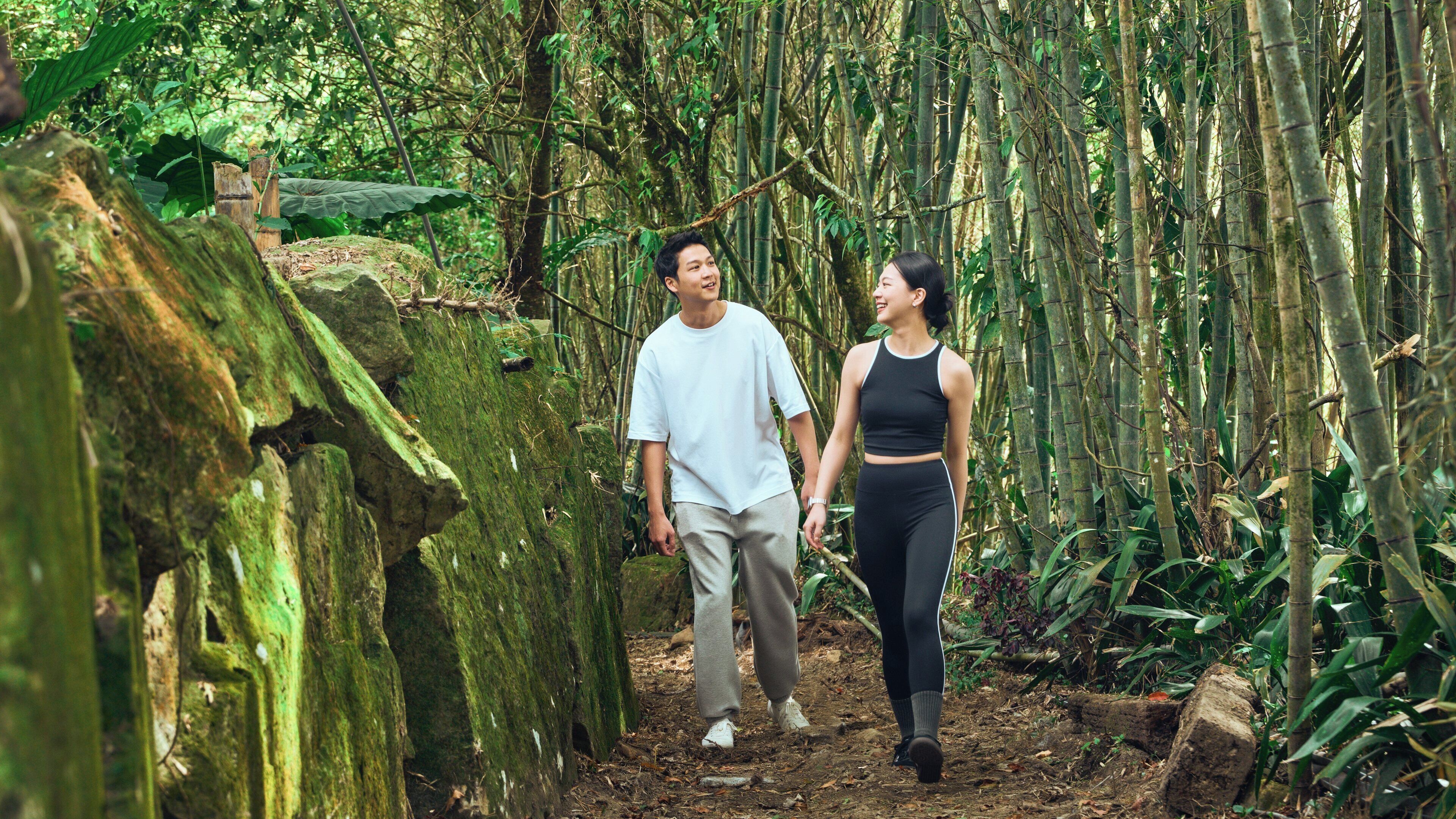 Un sendero arbolado con una pareja caminando.