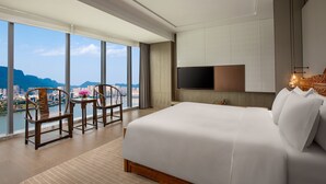 A modern hotel room with a large bed, a TV mounted on the wall, and a view of a cityscape through large windows. - Crowne Plaza Ya an by IHG (Ya'an)