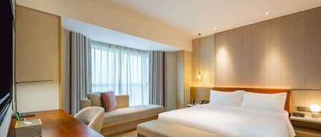 Ein Hotelzimmer mit Bett, Schreibtisch, Stuhl und Nachttisch.