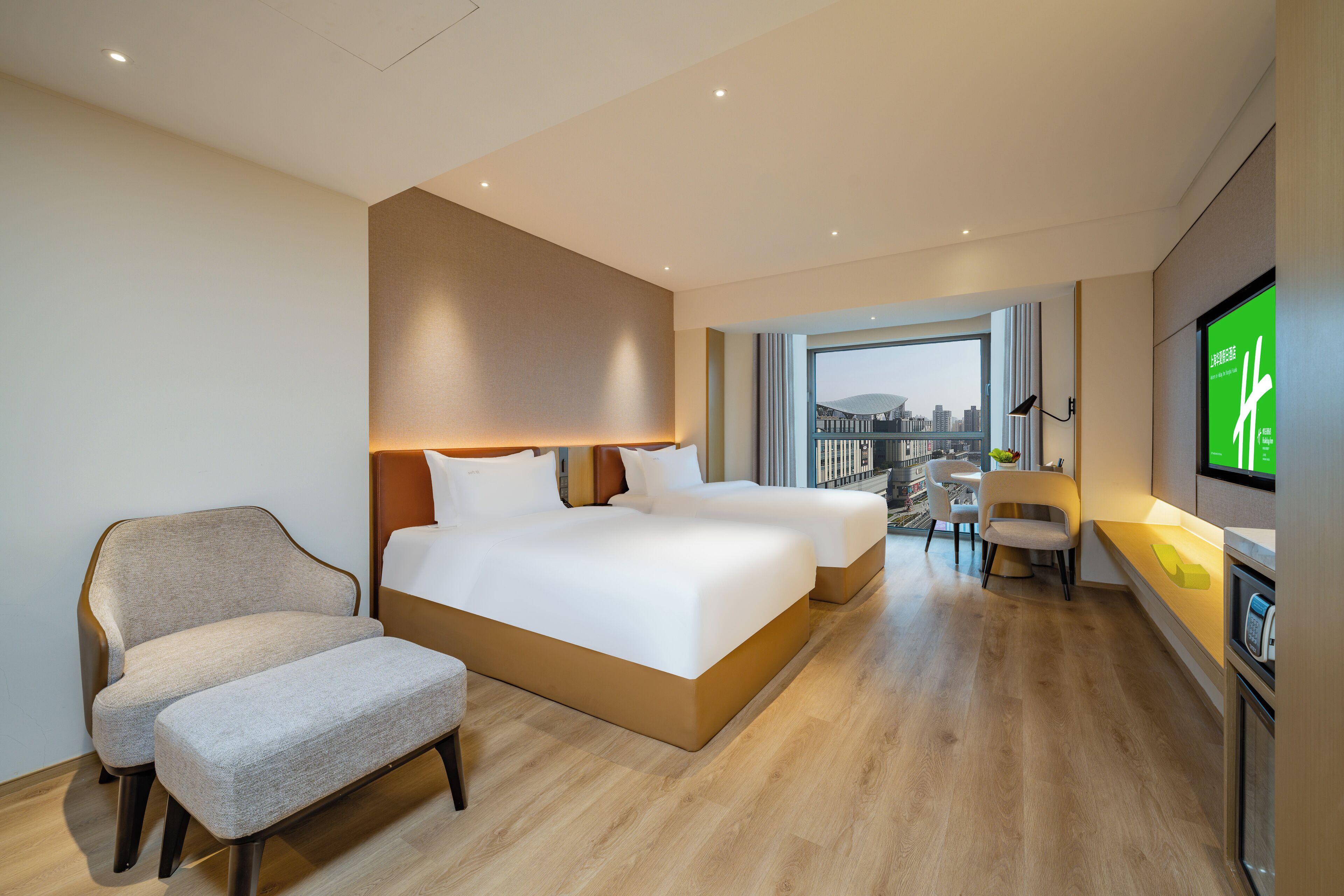 Una habitación de hotel con una cama grande, un sofá, un escritorio y un televisor.