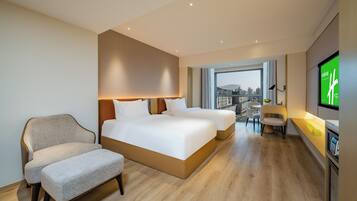 Una habitación de hotel con una cama grande, un sofá, un escritorio y un televisor.