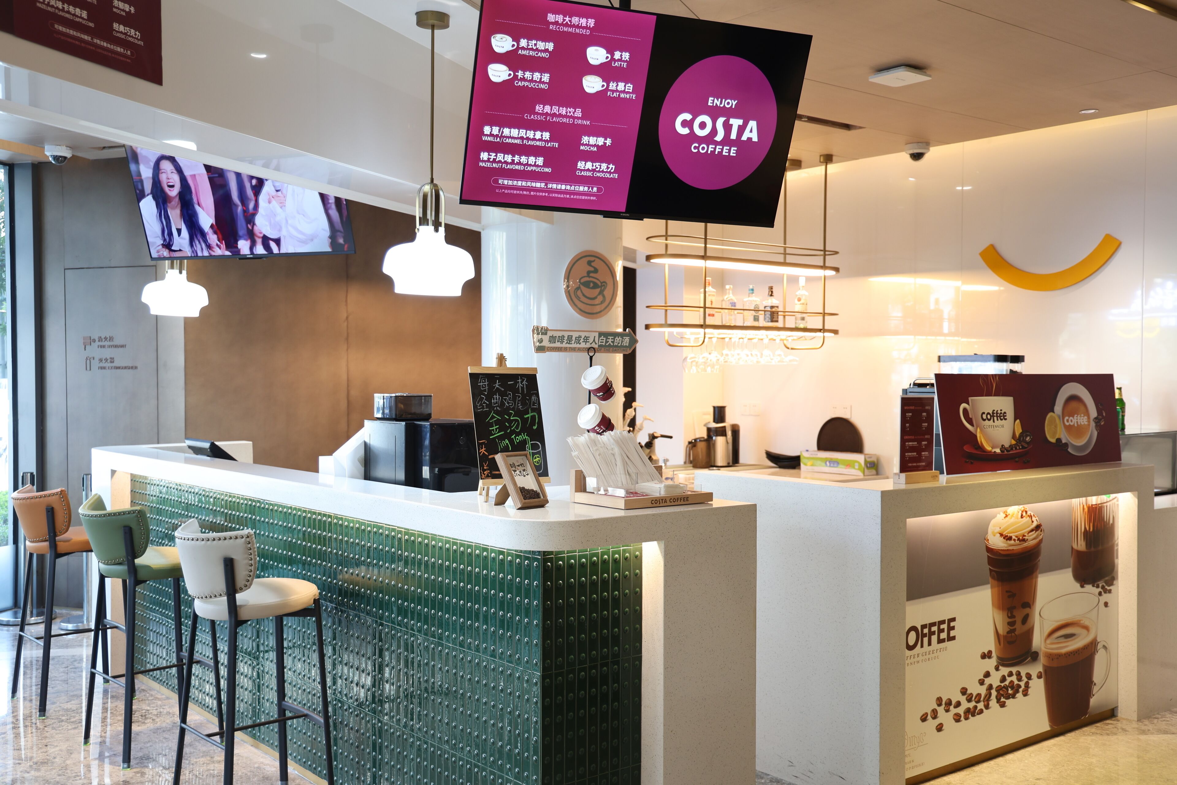 A modern coffee shop interior with a counter, bar stools, and a menu board.
