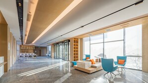 A spacious lobby with a marble floor, modern seating, and large windows offering a view of the outdoors. - Holiday Inn Express Suzhou Luzhi by IHG (Suzhou)