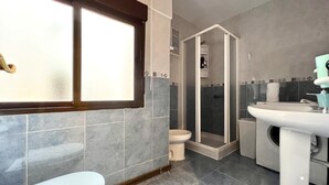 Un baño con inodoro, lavabo y ducha.