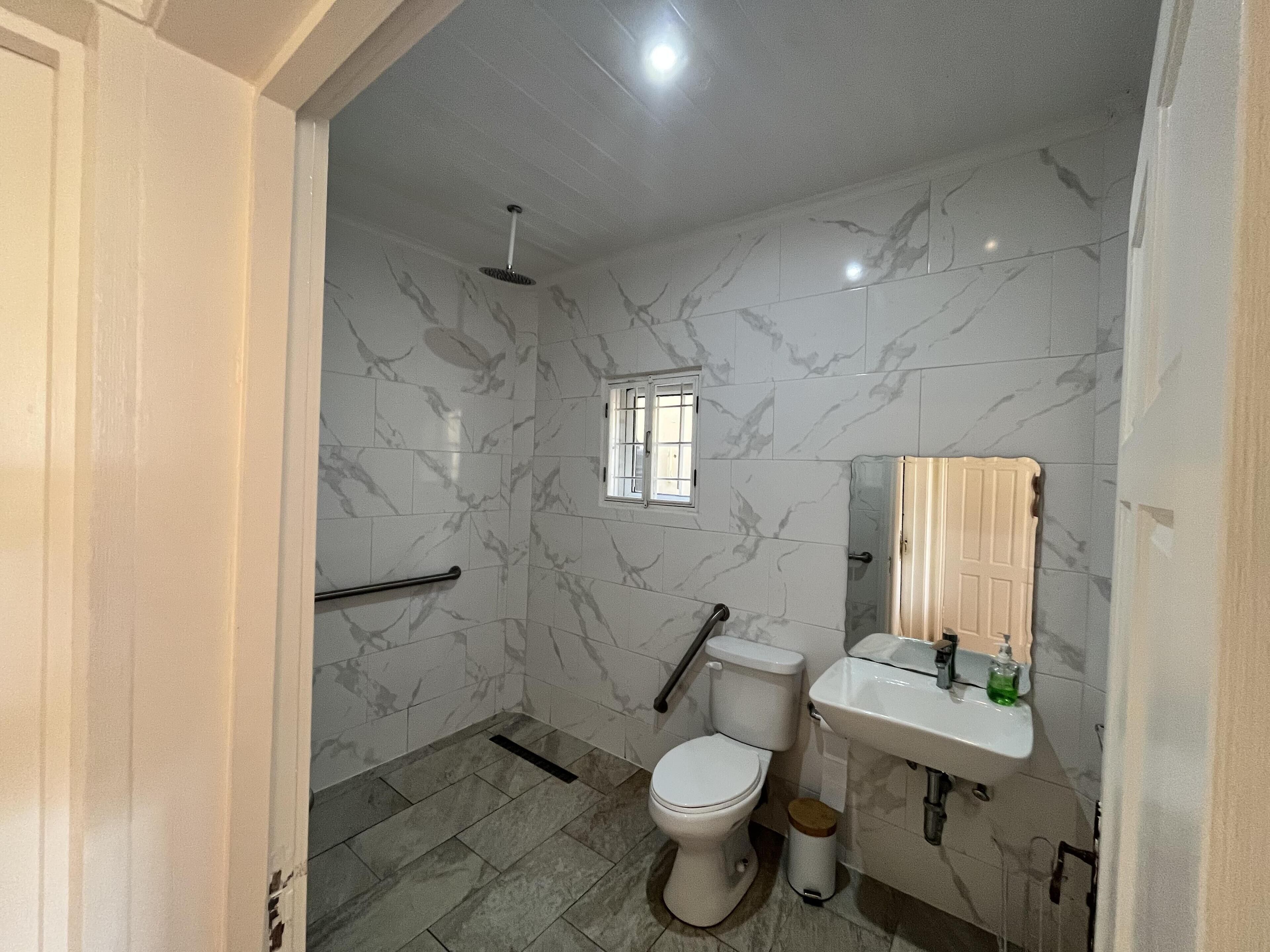 A bathroom with a toilet, sink, and shower.